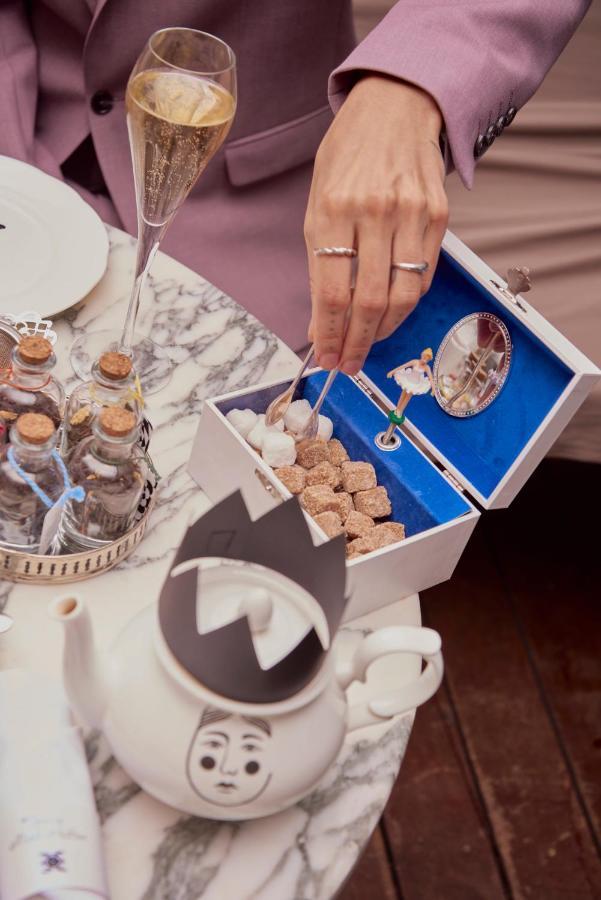 Sanderson London Eksteriør billede A woman using a sugar cube to clean a mirror